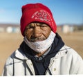 A masked squatter man with a red wool cap Royalty Free Stock Photo