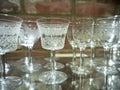 Victorian antique cut glass drinking glass collection on a reflective glass shelf