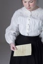 A Victorian or Edwardian woman wearing a white linen garibaldi blouse and black skirt Royalty Free Stock Photo