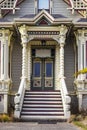 Victorian era gingerbread trimmed home entrance with steps up to front door and painted bric a brac