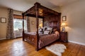 Victorian rectory bedroom with ornate carved four poster bed
