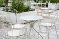 Victorian style white empty metal chairs and tables in outdoor cafe. Wrought iron furniture, old fashion cozy cafe terrace, Royalty Free Stock Photo