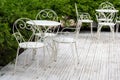 Victorian style white empty metal chairs and tables in outdoor cafe. Wrought iron furniture, old fashion cozy cafe terrace, Royalty Free Stock Photo