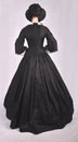 Victorian woman in black ensemble  on studio backdrop Royalty Free Stock Photo