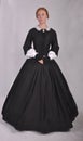 Victorian woman in black ensemble  on studio backdrop Royalty Free Stock Photo