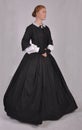 Victorian woman in black ensemble  on studio backdrop Royalty Free Stock Photo