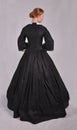 Victorian woman in black ensemble  on studio backdrop Royalty Free Stock Photo