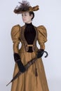 A Victorian woman wearing a bronze and brown silk ensemble