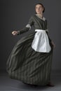 A working class Victorian woman wearing a dark green check bodice and skirt with an apron Royalty Free Stock Photo