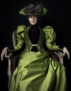 A Victorian woman wearing a green and brown silk ensemble