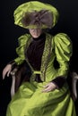 A Victorian woman wearing a green and brown silk ensemble