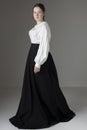 A Victorian or Edwardian woman wearing a white linen garibaldi blouse and black skirt Royalty Free Stock Photo