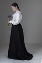 A Victorian or Edwardian woman wearing a white linen garibaldi blouse and black skirt Royalty Free Stock Photo