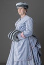 A Victorian woman wearing a pale blue velvet bustle ensemble with a fur muff and hat Royalty Free Stock Photo