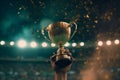 Victorious man holding gold trophy cup in night stadium Royalty Free Stock Photo