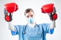 Victorious young female caucasian GP doctor wearing blue uniform red boxing gloves Royalty Free Stock Photo