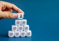 Award icon on white cube block in hand holding, put on top of white dices with target dart symbol on blocks pyramid shape. Royalty Free Stock Photo