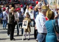 Victory Day in Moscow. Beautiful girl in military uniform with veteran`s portrait on Victory Day. Royalty Free Stock Photo
