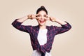 Victory and peace sign. Happy toothy smiley young woman holding hand on eyes and showing victory sign with satisfied face. Royalty Free Stock Photo