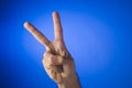 Victory sign on blue background