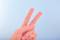 Victory sign and symbol of peace in form of two fingers on light blue background.Close up.Soft focus.ÃÂ¡oncept of success,a good