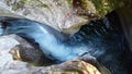 Aerial looking down raging rapids river funneling between two walls of rock in detail