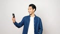 Video call conference, Happy asian man having a video chat on mobile phone while standing on grey background, Asia male talking Royalty Free Stock Photo