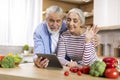 Video Call. Smiling Elderly Couple Using Digital Tablet In Kitchen For Teleconference Royalty Free Stock Photo