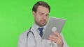 Video Call on Tablet by Young Doctor on Green Background