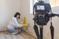 Video camera filming cheerful woman how removing mold from wall using spray bottle