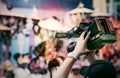 Cameraman lifts the camcorder above his head while filming video Royalty Free Stock Photo