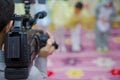 Video Camera recording kindergarder room with blurred background, copy space - Image . Video camera operator working with his Royalty Free Stock Photo