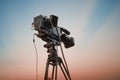 Video camera on tripod over sunset sky, TV professional studio Royalty Free Stock Photo