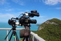 Video camera on a tripod on top of the mountain. Ocean and blue Royalty Free Stock Photo