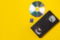 Video cassette videotape, compact disc, flash sd card on a yellow background. Flat lay concept Royalty Free Stock Photo