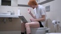 Video Chat on Laptop by Man Sitting on Toilet Commode