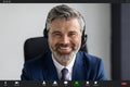 Video Conference. Smiling Middle Aged Businessman In Headset Making Virtual Call, POV Royalty Free Stock Photo