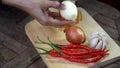 Video footage placing tempe chili pepper garlic shallot on paper plate on wooden table