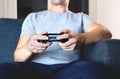 Video game controller in hand for console gaming. Gamer guy playing tv videogame with control gamepad or joystick while sitting. Royalty Free Stock Photo