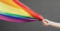 Video of hand of caucasian man with waiving rainbow fabric