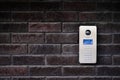 Video intercom on dark brick wall background. Modern, luxury, wealthy home security system. Alarm door bell. Safe entrance Royalty Free Stock Photo