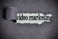 Video marketing word under torn black sugar paper