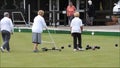 Senior members oap pensioners playing bowls bowling green outdoors active sports