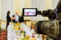 Video shooting at a restaurant at a Banquet. Camcorder with LCD display. People in the hall