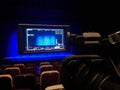 Video shooting in the theater. Digital camcorder with LCD display. Empty auditorium. Blue curtain on stage