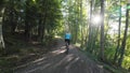 Video of woman cycling in the backlight of the sun on a dirt road