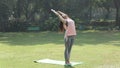 Video of woman doing Sun Salutation asana in garden.