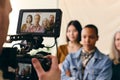 Videographer filming group of multiethnic women for International Women`s Day with digital image on camera screen