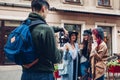 Videographer filming models on city street. Man using steadicam and camera to make footage. Video shoot Royalty Free Stock Photo