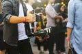 Videographer with gimball video DSLR in an event among people